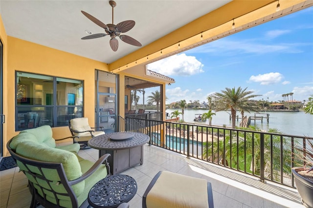 balcony with a water view and ceiling fan