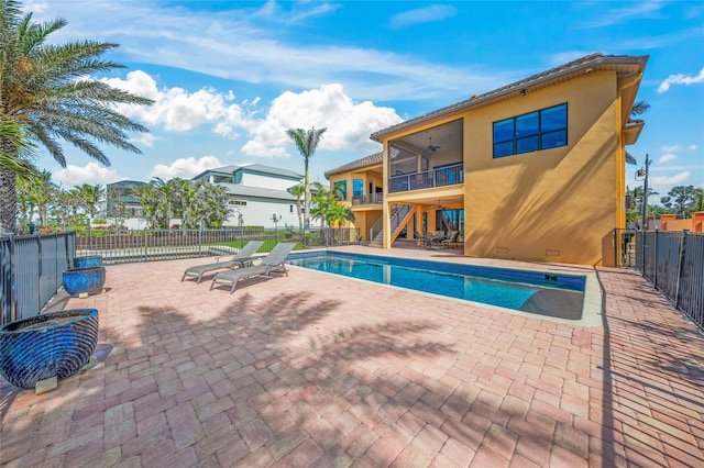 view of swimming pool featuring a patio, stairway, fence, and a fenced in pool