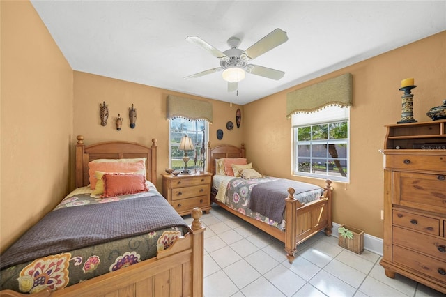 bedroom featuring light tile patterned floors, ceiling fan, and baseboards