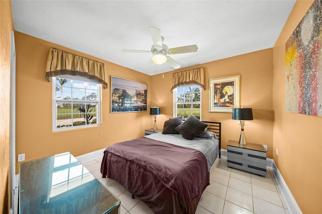 tiled bedroom featuring ceiling fan and baseboards