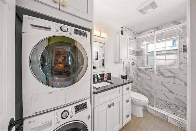 washroom featuring a sink, laundry area, visible vents, and stacked washer / drying machine