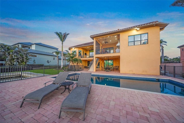 view of pool with a patio area, stairway, fence, and a ceiling fan