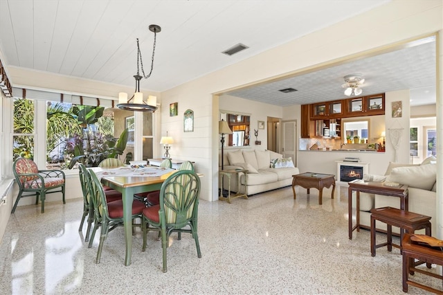 dining space with visible vents, light speckled floor, and a glass covered fireplace