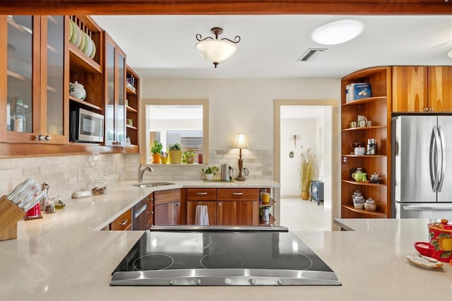 kitchen featuring a sink, appliances with stainless steel finishes, light countertops, and open shelves