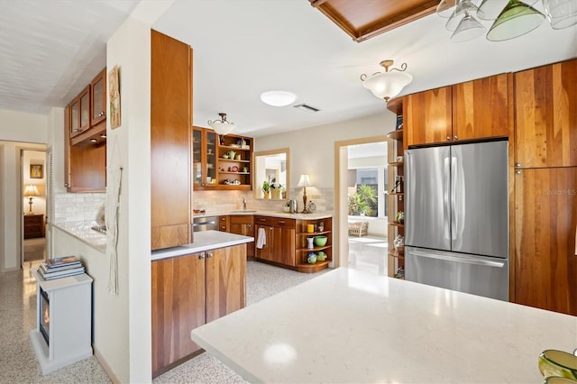 kitchen with brown cabinetry, visible vents, stainless steel appliances, and open shelves