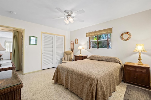 bedroom with a closet, ceiling fan, light speckled floor, and baseboards