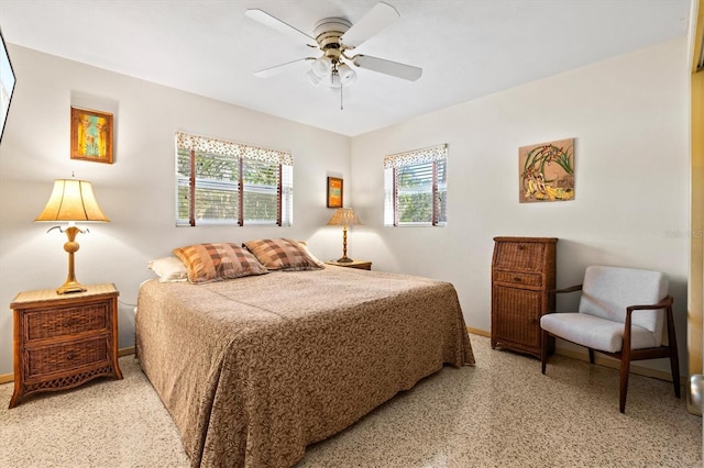 bedroom with baseboards, light speckled floor, and a ceiling fan