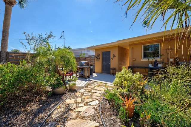 view of front facade with stucco siding, fence, and a patio area