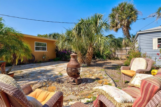 view of yard featuring a patio, a fire pit, and fence