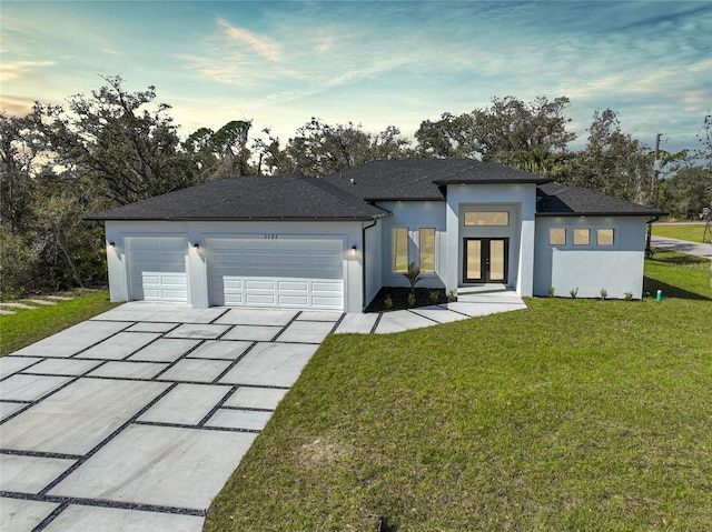 view of front of property with a garage, driveway, french doors, stucco siding, and a front yard