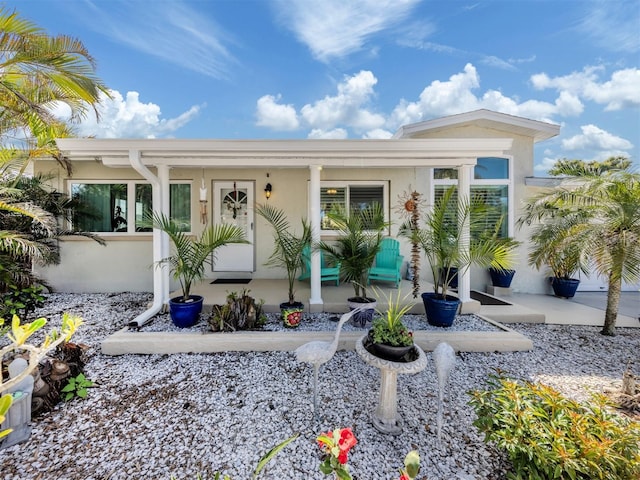 exterior space with a porch and stucco siding