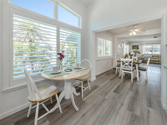 dining space featuring light wood finished floors, ceiling fan, and baseboards