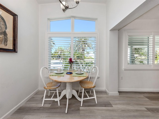 dining room with baseboards, a chandelier, and wood finished floors