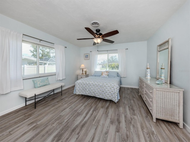 bedroom featuring baseboards, visible vents, and wood finished floors