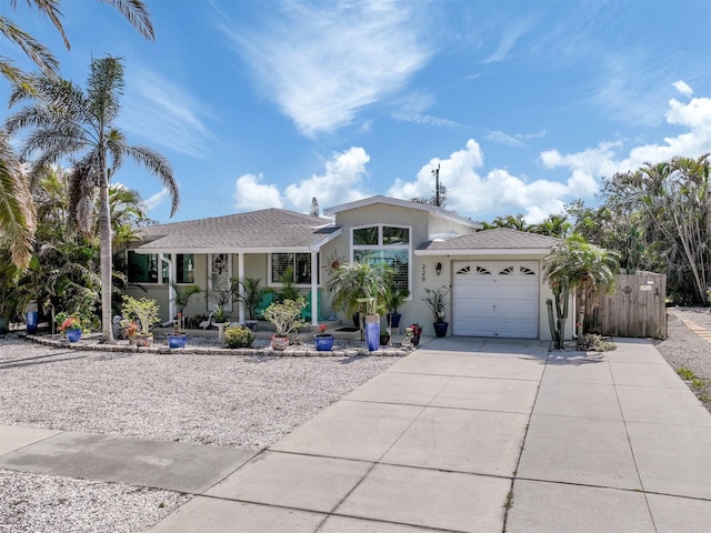 view of front of home with driveway, a shingled roof, an attached garage, and stucco siding