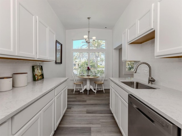 kitchen with an inviting chandelier, white cabinetry, a sink, light stone countertops, and dishwasher