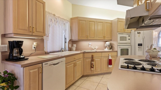 kitchen with a sink, light brown cabinets, white appliances, under cabinet range hood, and light tile patterned flooring