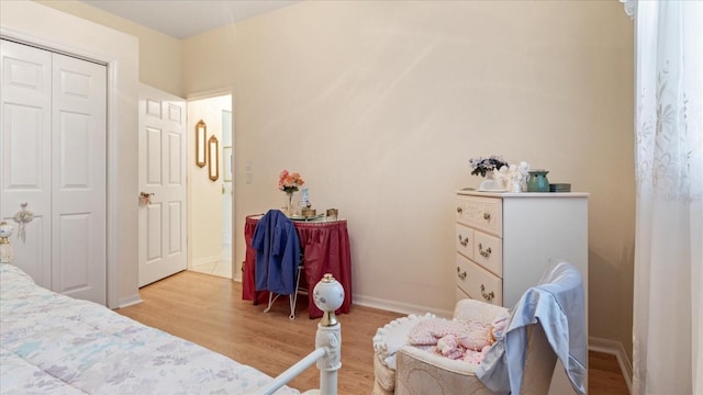 bedroom featuring a closet, light wood-type flooring, and baseboards