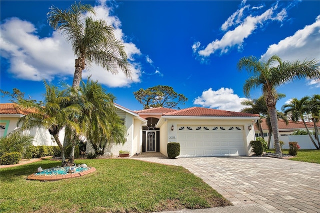 view of front of property with a garage, a tiled roof, decorative driveway, stucco siding, and a front yard