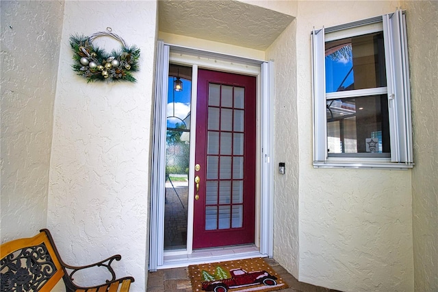 view of exterior entry featuring stucco siding