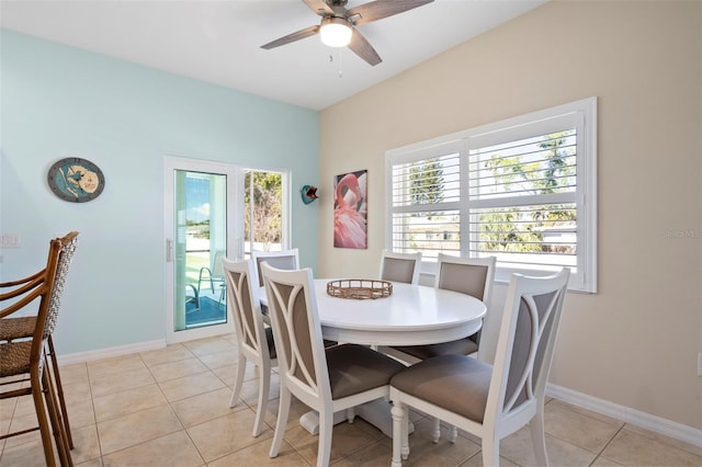 dining space featuring baseboards, a ceiling fan, and light tile patterned flooring