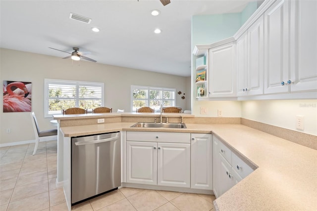 kitchen featuring light countertops, dishwasher, and white cabinetry