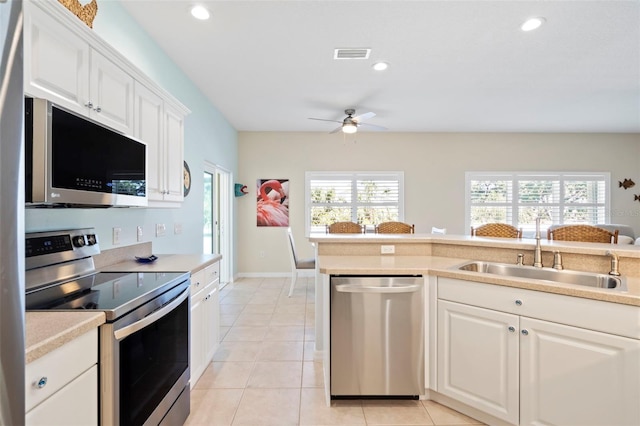 kitchen featuring light countertops, appliances with stainless steel finishes, a sink, and white cabinetry