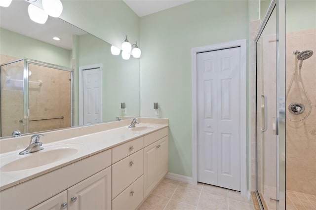 full bathroom with a sink, a stall shower, tile patterned flooring, and a closet