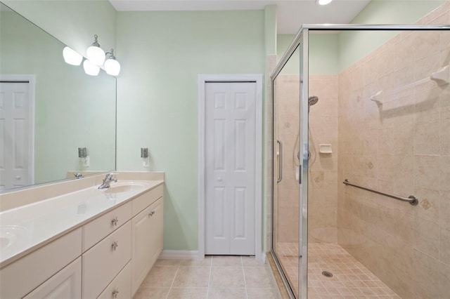 full bath with double vanity, a closet, tile patterned flooring, and a sink