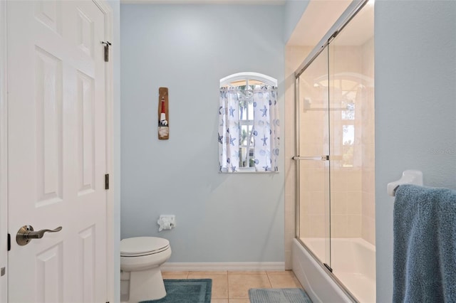 bathroom with baseboards, combined bath / shower with glass door, toilet, and tile patterned floors