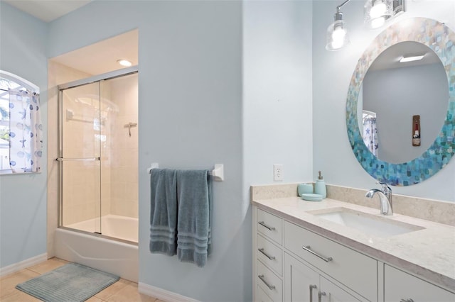 bathroom featuring combined bath / shower with glass door, vanity, baseboards, and tile patterned floors