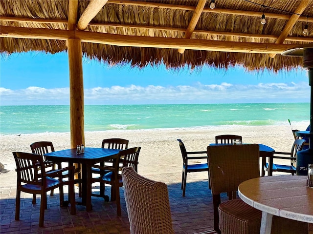 view of patio / terrace with a water view and a view of the beach