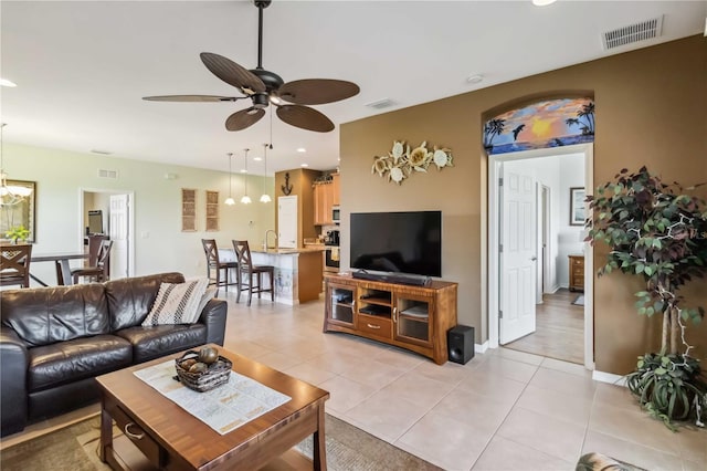 living room featuring a ceiling fan, visible vents, and light tile patterned floors