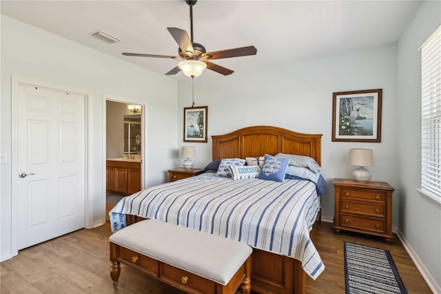 bedroom featuring a ceiling fan, baseboards, visible vents, and wood finished floors