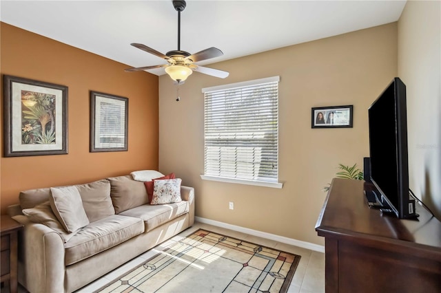 living room featuring ceiling fan, light tile patterned flooring, and baseboards