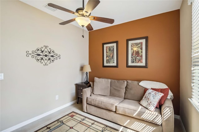 living area with visible vents, baseboards, and a ceiling fan