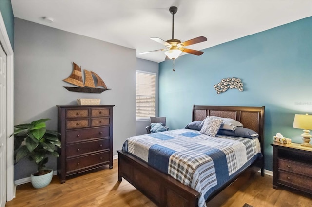 bedroom featuring ceiling fan, wood finished floors, and baseboards