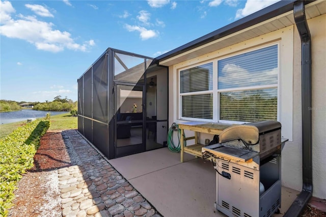 view of patio with a lanai, a water view, and a grill