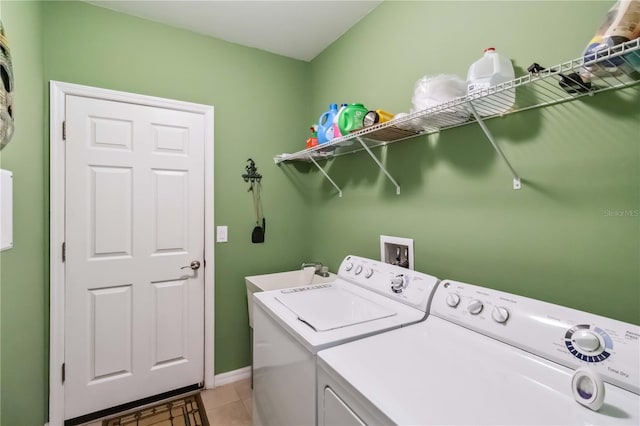 laundry area featuring light tile patterned flooring, a sink, separate washer and dryer, laundry area, and baseboards