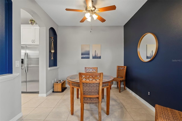 1050 Jonah Dr, North Port, FL 34289 - dining area featuring light tile patterned floors, arched walkways, a ceiling fan, and baseboards