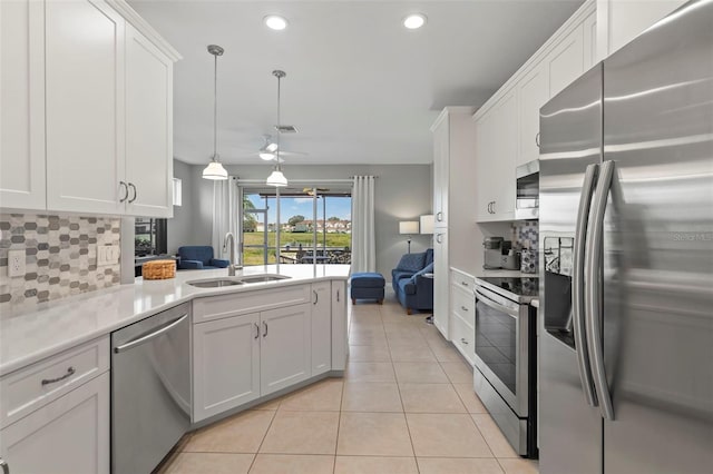 1050 Jonah Dr, North Port, FL 34289 - kitchen featuring light tile patterned floors, stainless steel appliances, tasteful backsplash, white cabinets, and a sink