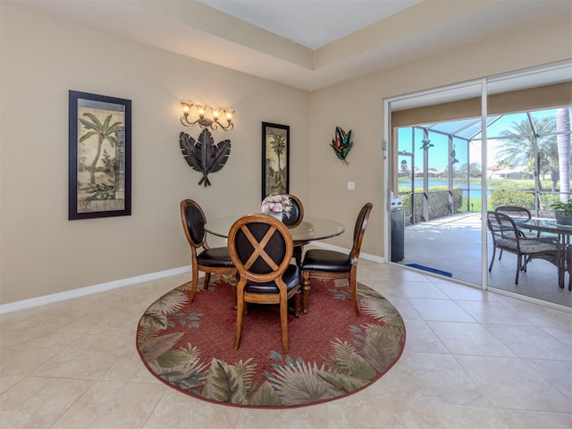 dining space featuring light tile patterned floors, baseboards, and a sunroom