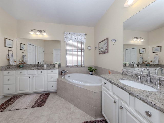 bathroom with two vanities, a sink, a bath, and tile patterned floors