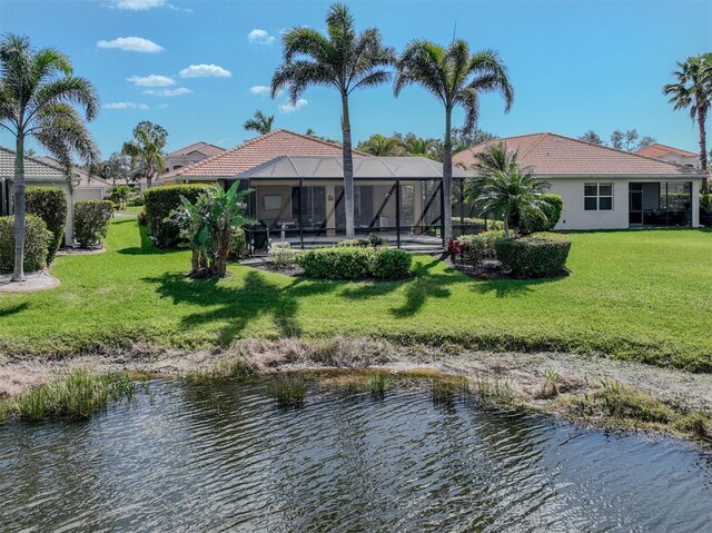 back of house with a tiled roof, a lawn, a lanai, and stucco siding