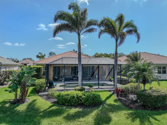 rear view of property featuring a patio, a lawn, a lanai, an outdoor pool, and a tiled roof