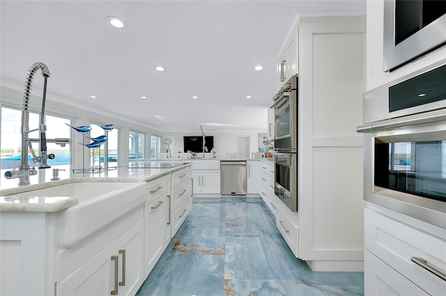 kitchen featuring marble finish floor, crown molding, recessed lighting, white cabinets, and a sink