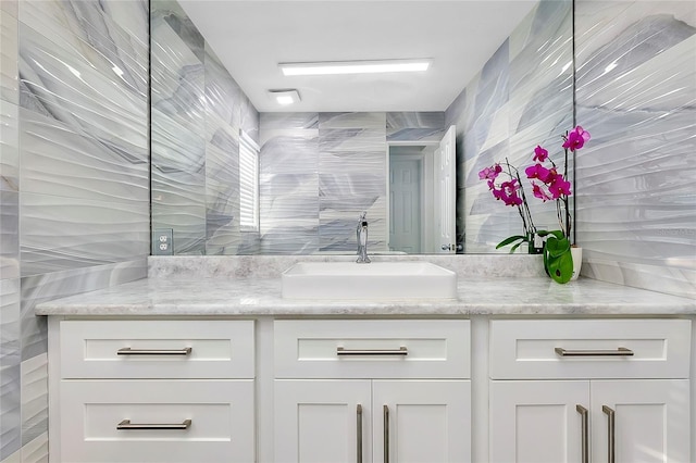 full bath featuring a tile shower and vanity