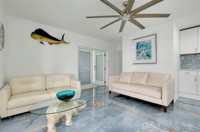 living area featuring a ceiling fan and marble finish floor