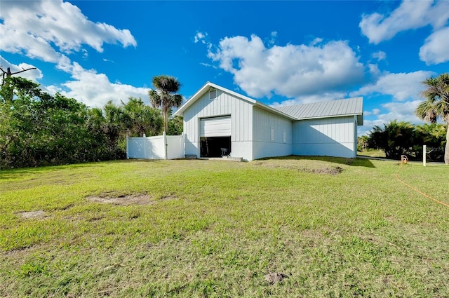 view of pole building with fence and a lawn