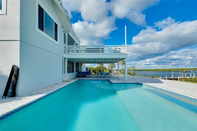 outdoor pool featuring a patio and a water view